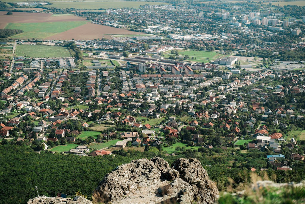 Breathtaking aerial view of Nitra cityscape surrounded by lush greenery and rolling hills.